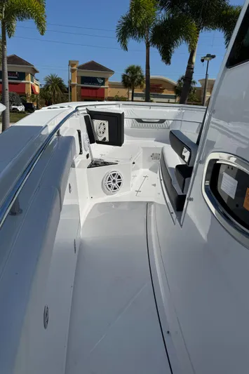  Yacht Photos Pics 2025 Blackfin 332 CC boat interior with seating and speaker, surrounded by palm trees.