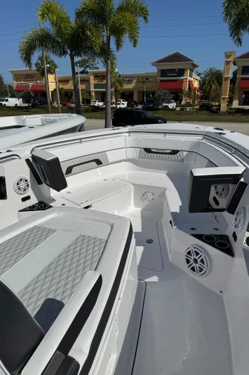  Yacht Photos Pics 2025 Blackfin 332 CC boat interior with seating, speakers, and palm trees in the background.