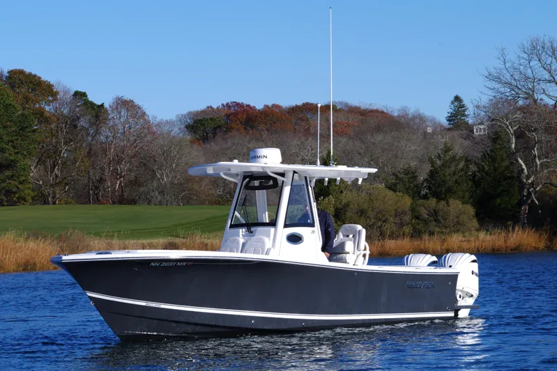  Yacht Photos Pics 2023 Regulator 28 boat on a calm lake with autumn trees in the background.