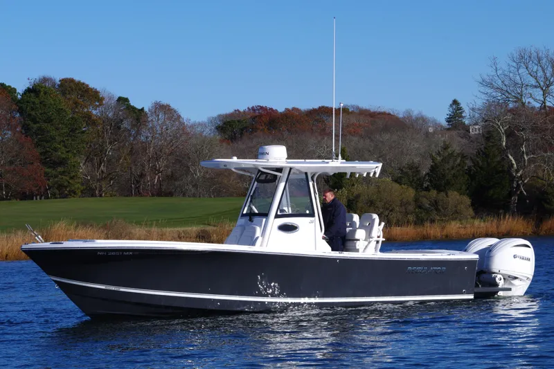  Yacht Photos Pics 2023 Regulator 28 boat cruising on a calm lake with scenic background.