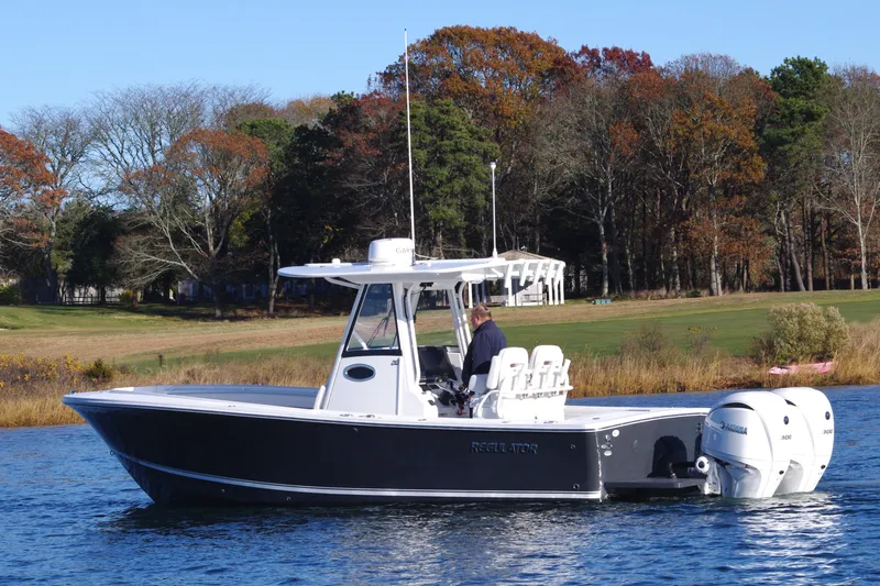  Yacht Photos Pics 2023 Regulator 28 boat on water, surrounded by autumn trees.