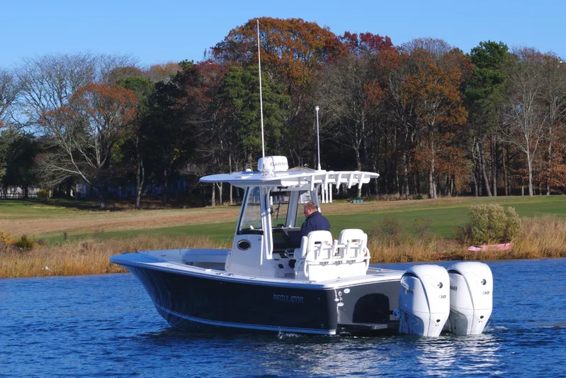  Yacht Photos Pics 2023 Regulator 28 boat on a lake with autumn trees in the background.