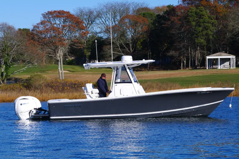  Yacht Photos Pics 2023 Regulator 28 boat on calm water with scenic background.