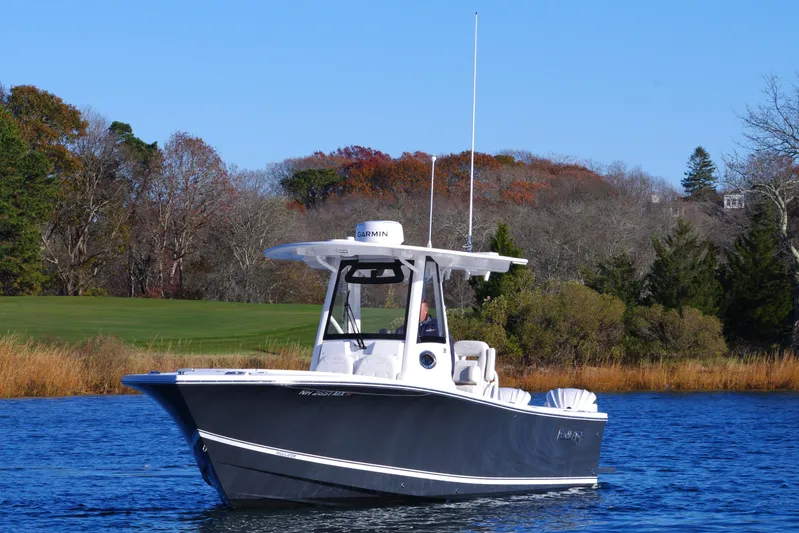  Yacht Photos Pics 2023 Regulator 28 boat on calm water with scenic background.