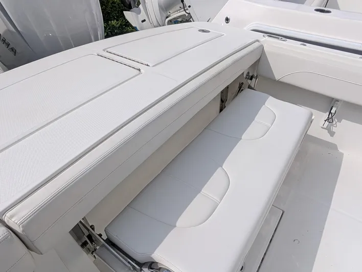  Yacht Photos Pics 2023 Regulator 28 boat interior with white cushioned seating and storage compartments.