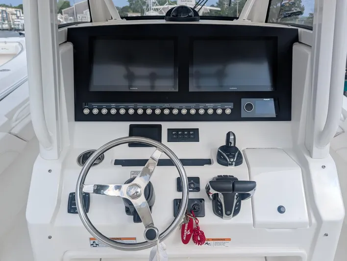  Yacht Photos Pics 2023 Regulator 28 boat dashboard with dual screens and steering wheel.