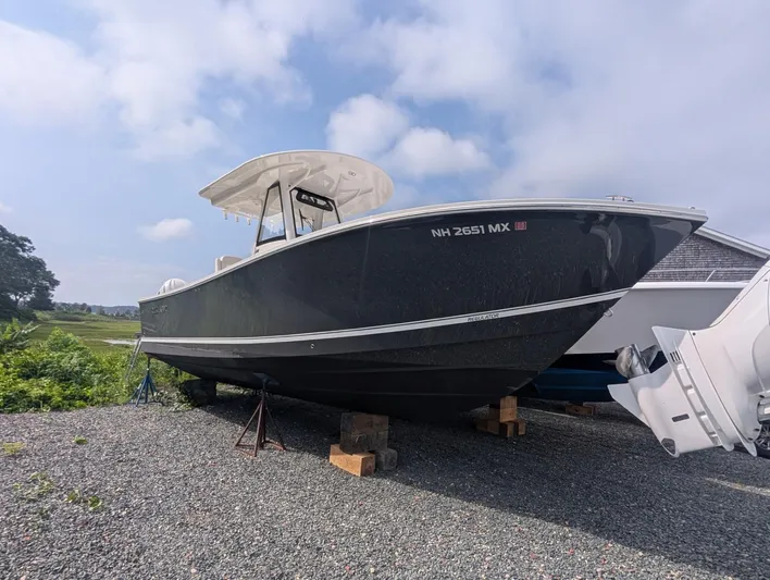  Yacht Photos Pics 2023 Regulator 28 boat on gravel, under a partly cloudy sky.
