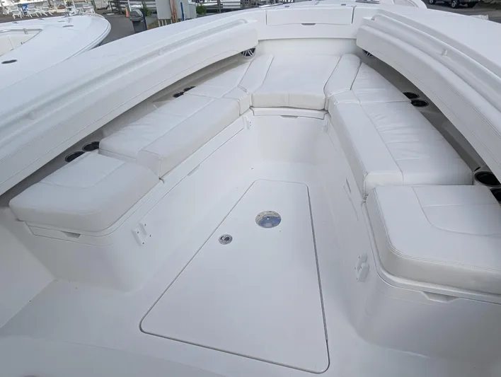  Yacht Photos Pics 2023 Regulator 28 boat interior with white cushioned seating and storage compartments.