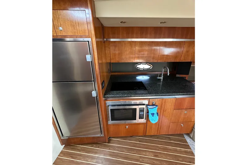  Yacht Photos Pics 2006 Cruisers Yachts 420 Express kitchen with stainless appliances and wood cabinetry.