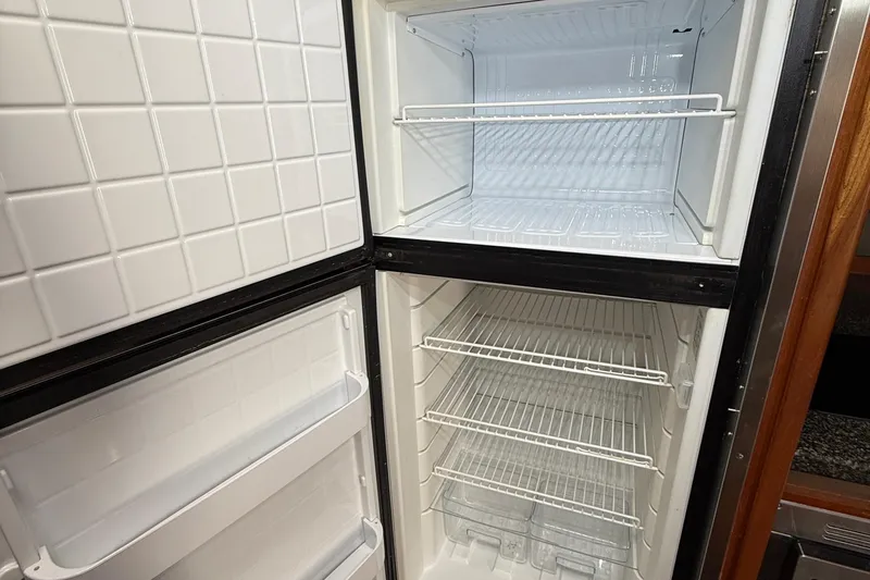  Yacht Photos Pics Empty refrigerator inside 2006 Cruisers Yachts 420 Express, featuring spacious shelving.