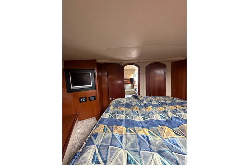  Yacht Photos Pics Interior of 2006 Cruisers Yachts 420 Express with bed, TV, and wooden cabinetry.