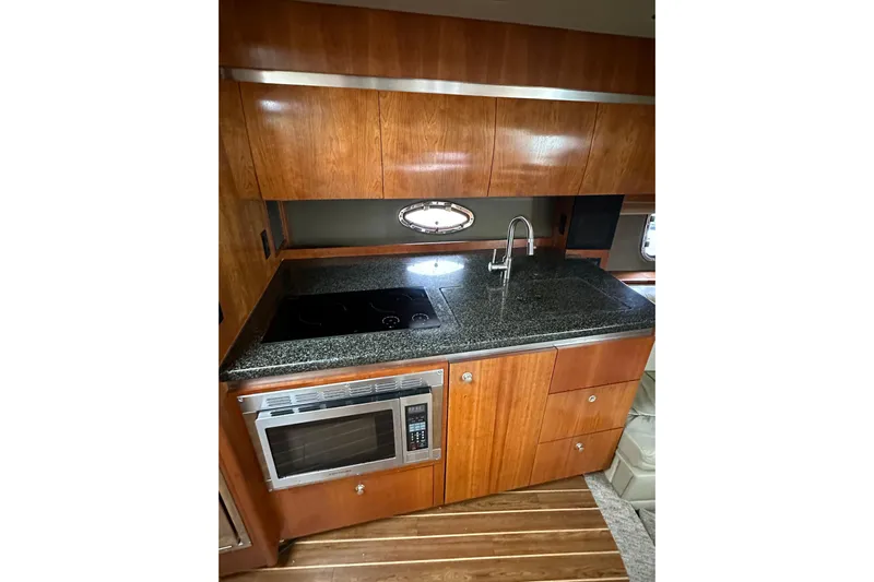  Yacht Photos Pics 2006 Cruisers Yachts 420 Express kitchen with wood cabinets and modern appliances.
