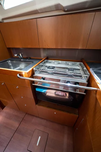 Orion Yacht Photos Pics 2017 Beneteau Oceanis 41.1 yacht kitchen with wood cabinetry, sink, and stove.