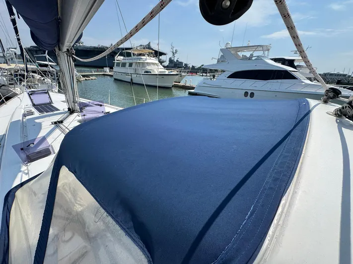 Halcyon Yacht Photos Pics 2017 Beneteau Oceanis 48 sailboat docked in a marina, featuring a blue deck cover.