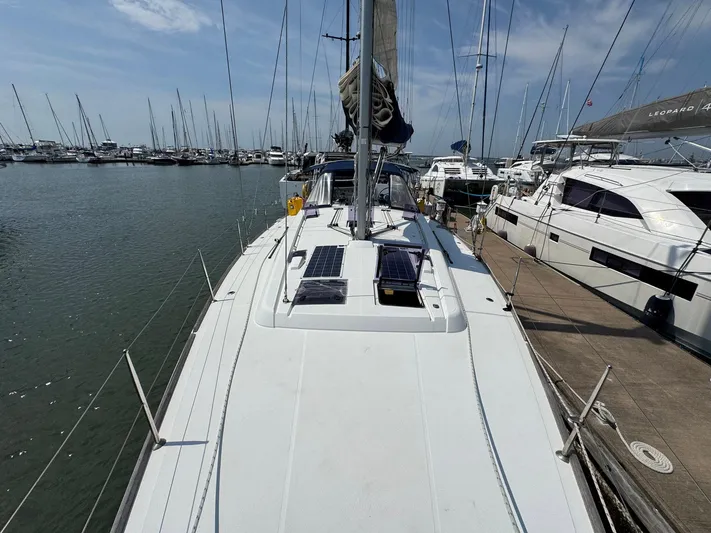 Halcyon Yacht Photos Pics 2017 Beneteau Oceanis 48 sailboat docked in a marina under a clear sky.