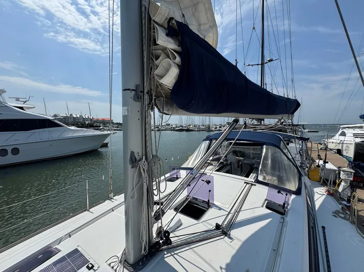 Halcyon Yacht Photos Pics 2017 Beneteau Oceanis 48 sailboat docked in a marina under a clear blue sky.