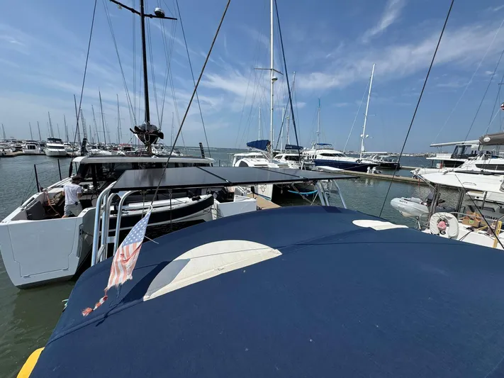 Halcyon Yacht Photos Pics 2017 Beneteau Oceanis 48 sailboat docked in a marina under clear blue skies.