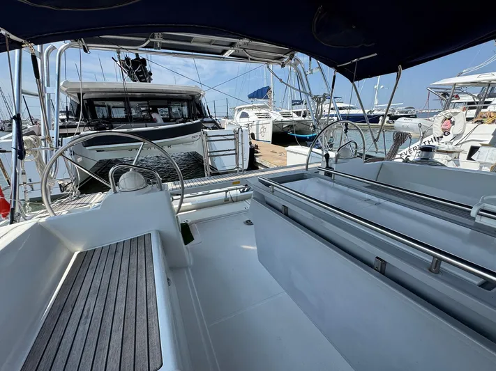 Halcyon Yacht Photos Pics 2017 Beneteau Oceanis 48 yacht cockpit with dual steering wheels, docked at marina.