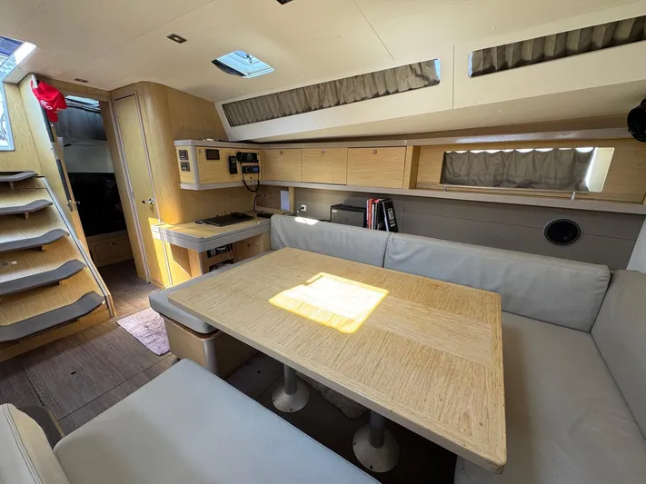 Halcyon Yacht Photos Pics Interior of 2017 Beneteau Oceanis 48 yacht with modern dining area and kitchenette.