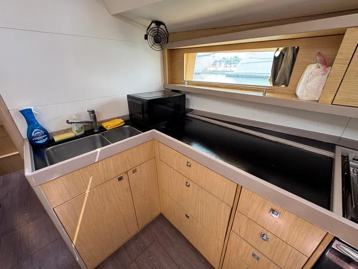 Halcyon Yacht Photos Pics Modern kitchen in 2017 Beneteau Oceanis 48 yacht with sleek cabinetry and appliances.