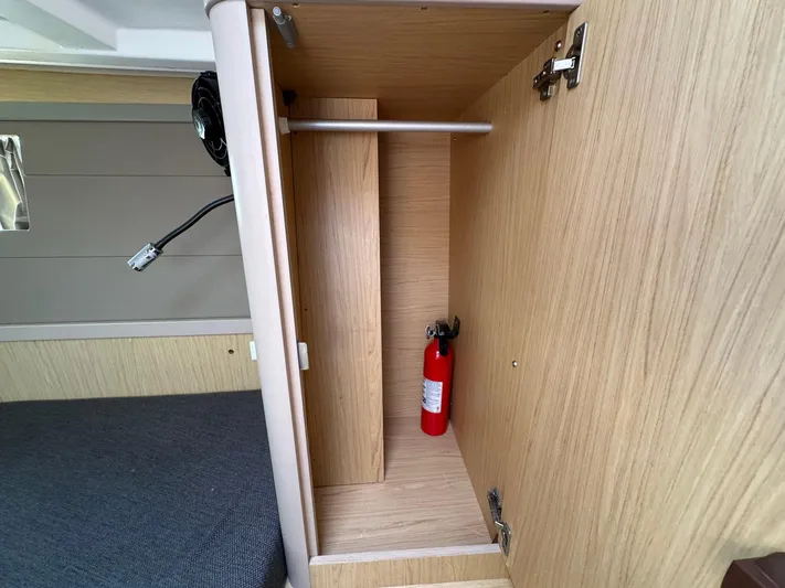 Halcyon Yacht Photos Pics Open cabinet in 2017 Beneteau Oceanis 48 yacht with fire extinguisher inside.