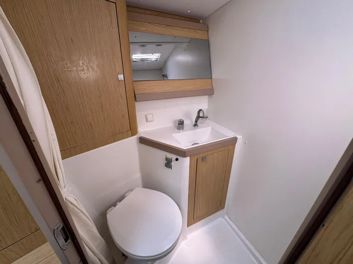 Halcyon Yacht Photos Pics 2017 Beneteau Oceanis 48 bathroom with wooden cabinetry and modern fixtures.