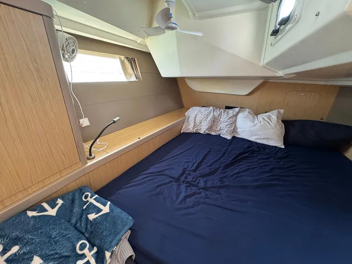 Halcyon Yacht Photos Pics Cozy cabin interior of 2017 Beneteau Oceanis 48 with bed and nautical decor.