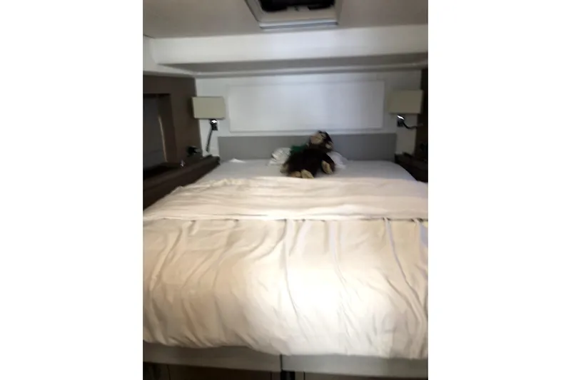  Yacht Photos Pics Luxurious bedroom interior of 2019 Prestige 590 yacht with plush bedding and modern lighting.