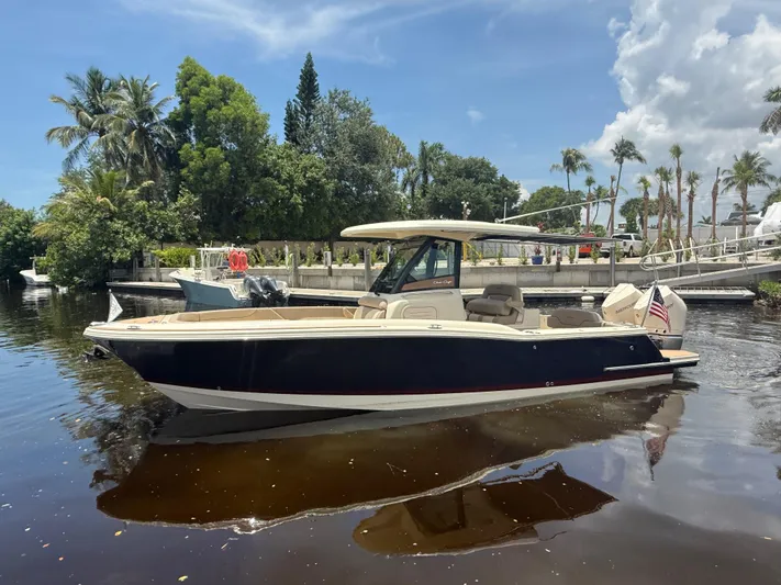  Yacht Photos Pics 2025 Chris-Craft Catalina 28 boat on calm water, surrounded by lush greenery.