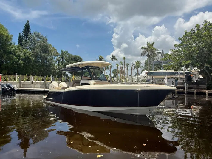  Yacht Photos Pics 2025 Chris-Craft Catalina 28 boat docked on a sunny day with lush greenery.