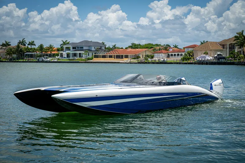 Yacht Photos Pics 2023 Performance Powerboats P360 cruising on a scenic waterfront with luxury homes.