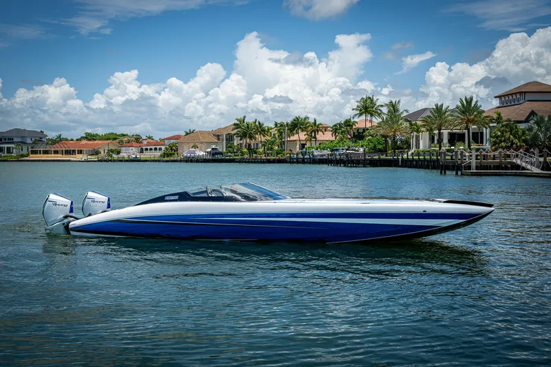  Yacht Photos Pics 2023 Performance Powerboats P360 on water, sleek design, vibrant blue and white colors, luxury waterfront homes.