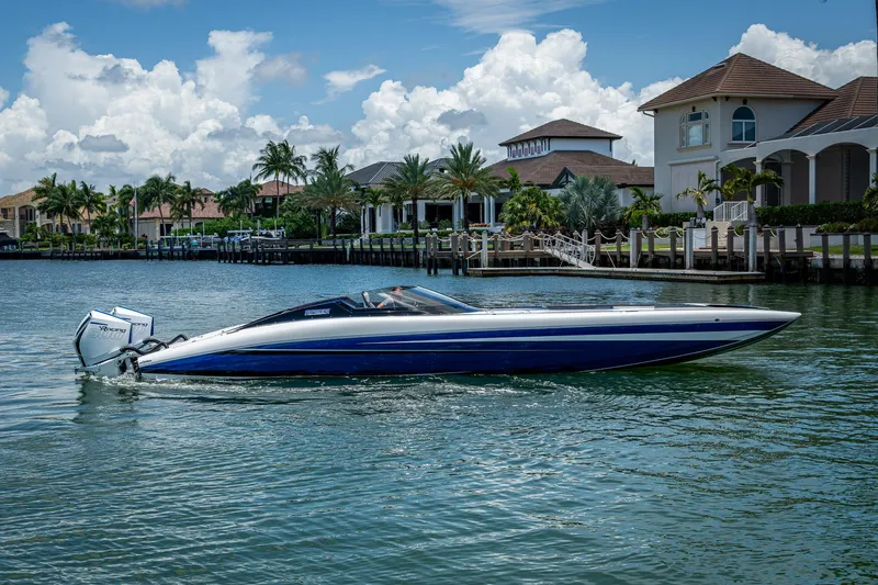  Yacht Photos Pics 2023 Performance Powerboats P360 cruising on a scenic waterfront with luxury homes.