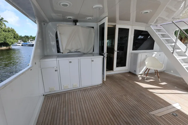 Ocean Drive Yacht Photos Pics 1988 Broward 124 Tri-Deck MY yacht deck with wooden flooring and white cabinetry.