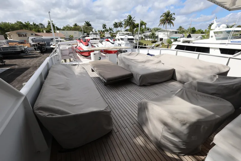 Ocean Drive Yacht Photos Pics 1988 Broward 124 Tri-Deck MY yacht deck with covered seating and jet skis.