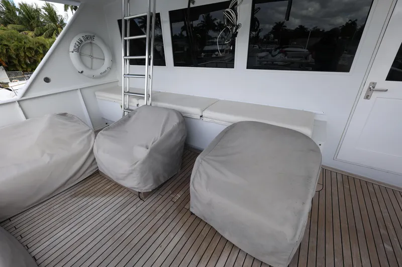 Ocean Drive Yacht Photos Pics 1988 Broward 124 Tri-Deck MY yacht deck with covered seating and wooden flooring.