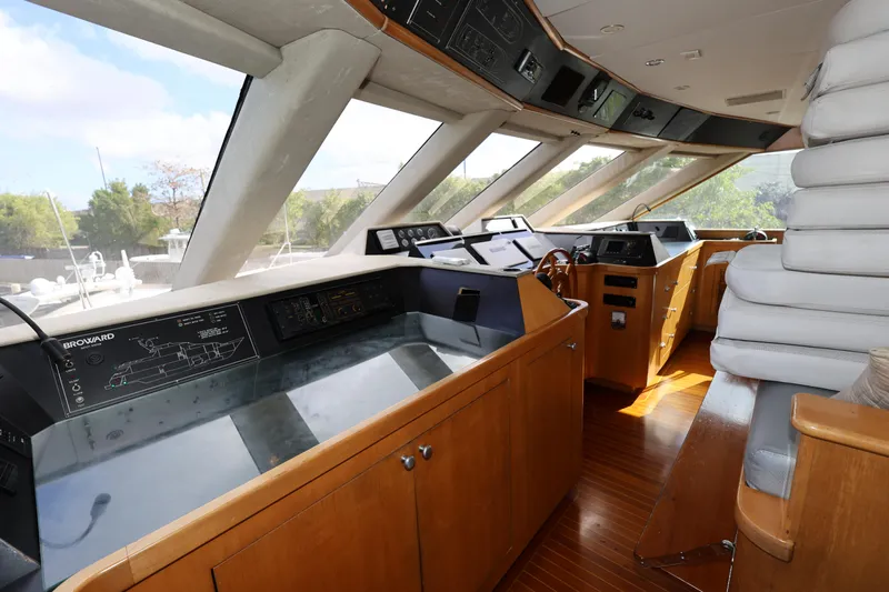Ocean Drive Yacht Photos Pics Interior helm of 1988 Broward 124 Tri-Deck MY yacht with wooden cabinetry and navigation equipment.
