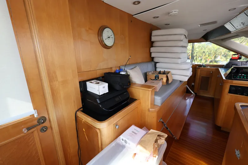 Ocean Drive Yacht Photos Pics Interior of 1988 Broward 124 Tri-Deck MY yacht with wooden furnishings and stacked cushions.