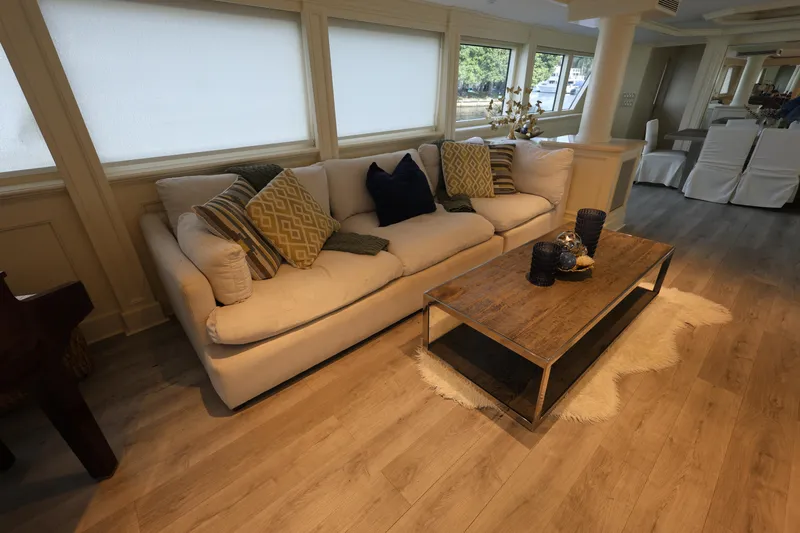 Ocean Drive Yacht Photos Pics Luxurious 1988 Broward 124 Tri-Deck MY interior with elegant sofa and wooden coffee table.