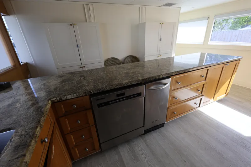 Ocean Drive Yacht Photos Pics Spacious kitchen with granite countertops and wooden cabinets on a 1988 Broward 124 Tri-Deck MY.