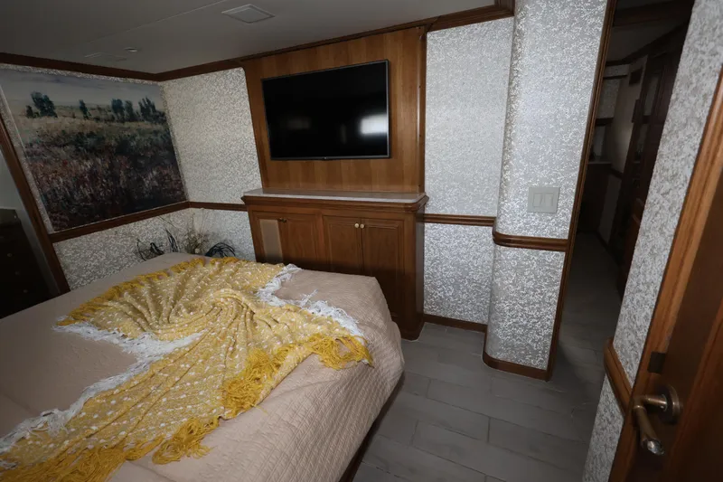 Ocean Drive Yacht Photos Pics Luxurious bedroom interior of 1988 Broward 124 Tri-Deck MY yacht with TV and elegant decor.