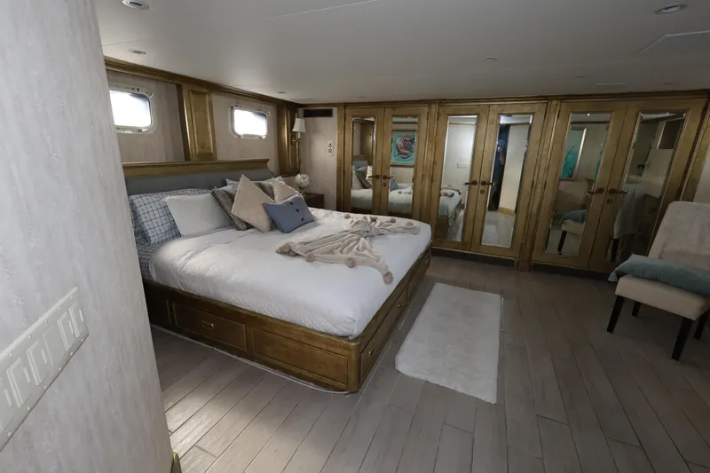 Ocean Drive Yacht Photos Pics Luxurious bedroom on 1988 Broward 124 Tri-Deck MY yacht with elegant decor and mirrored closets.