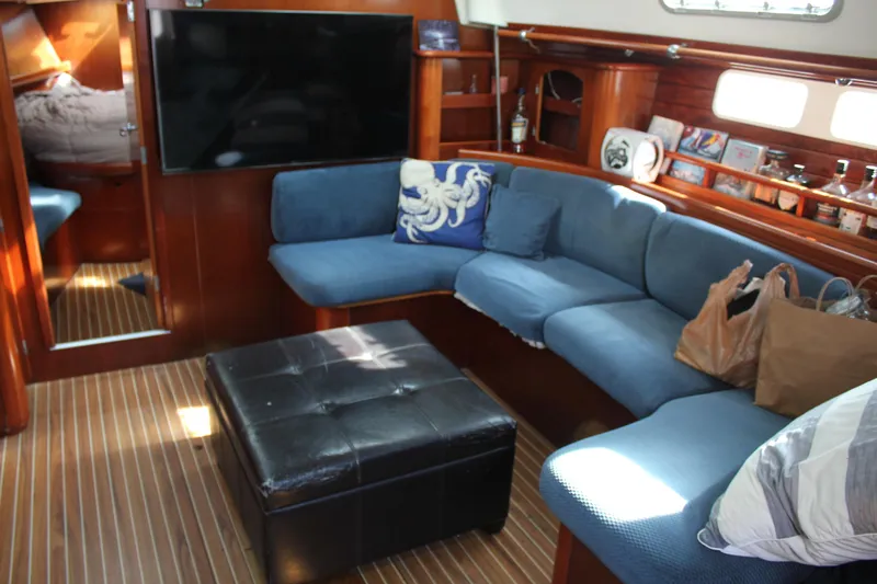 Hawaiian Passage Yacht Photos Pics Interior of 1997 Beneteau Oceanis 461 yacht with blue seating and wooden accents.