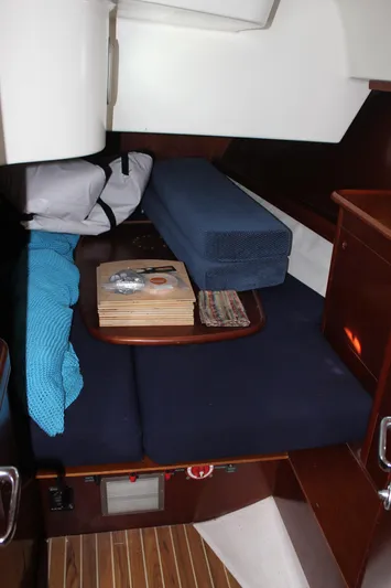 Hawaiian Passage Yacht Photos Pics 1997 Beneteau Oceanis 461 cabin interior with blue cushions and wooden accents.