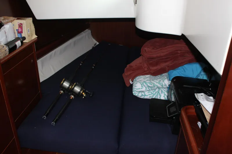 Hawaiian Passage Yacht Photos Pics Interior cabin of 1997 Beneteau Oceanis 461 with fishing rods and bedding.