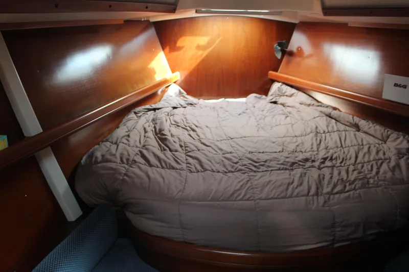 Hawaiian Passage Yacht Photos Pics Cozy cabin interior of 1997 Beneteau Oceanis 461 sailboat with wooden finish and bedding.