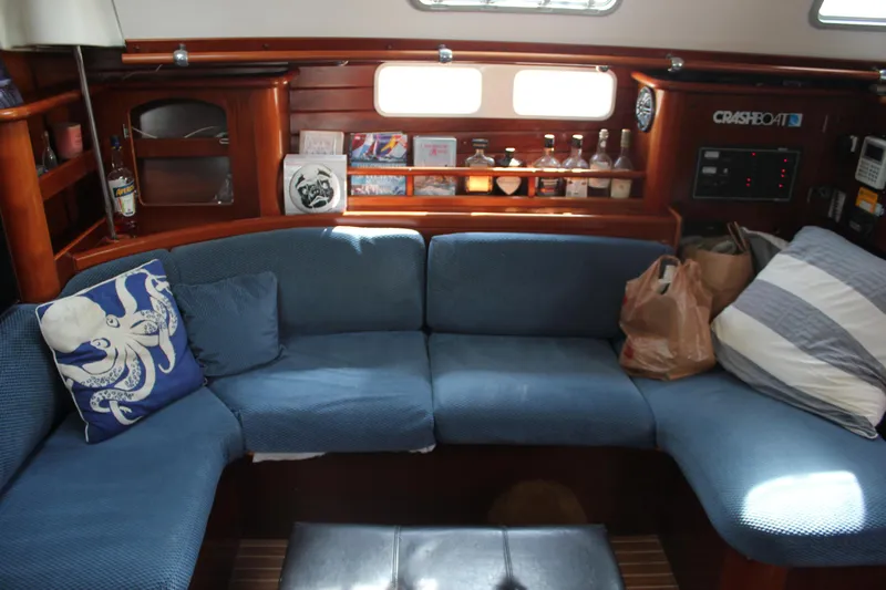 Hawaiian Passage Yacht Photos Pics Interior of 1997 Beneteau Oceanis 461 sailboat with blue seating and wooden shelves.