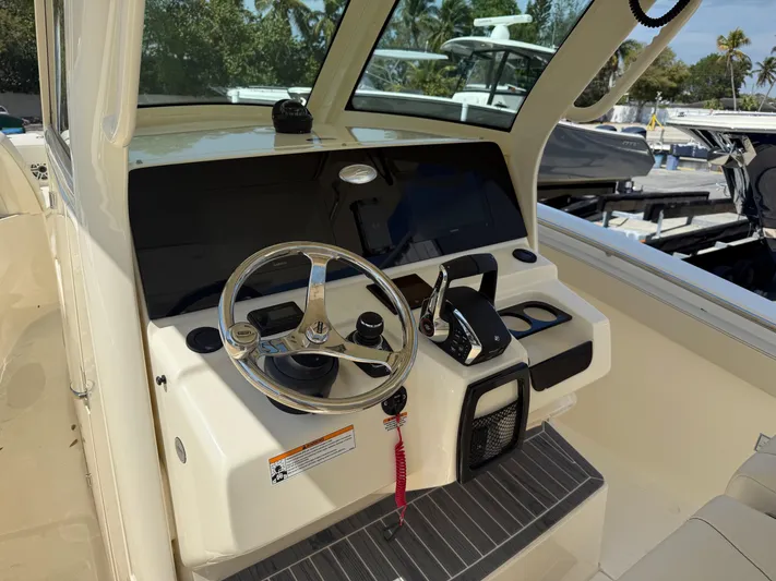  Yacht Photos Pics 2025 Scout 305 LXF boat helm with steering wheel and controls.