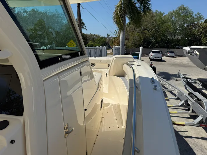  Yacht Photos Pics 2025 Scout 305 LXF boat, side view, parked outdoors under clear sky.