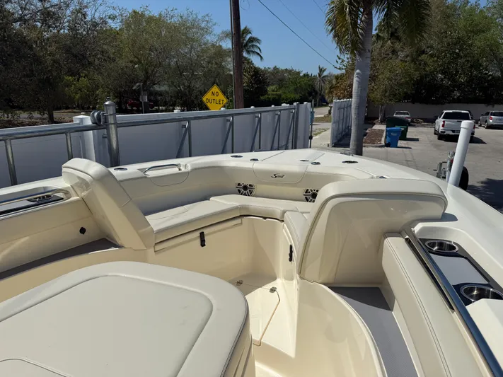  Yacht Photos Pics 2025 Scout 305 LXF boat interior with seating and cup holders, parked outdoors.